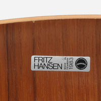 アルネ・ヤコブセンがデザインし、Fritz Hansenが製造した「T Chair」です。チーク材の成形合板による背座一体型のシェルは、背面上部を左右に広げた特徴的なシルエットと、身体に沿う緩やかな曲面が魅力。細身の金属脚との組み合わせが軽快で、ダイニングはもちろん、書斎や玄関のアクセントチェアにもおすすめです。美しい木目と時を重ねた風合い、合理的な構造に宿る北欧ビンテージらしい存在感を楽しめます。
