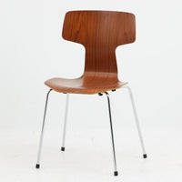 アルネ・ヤコブセンがデザインし、Fritz Hansenが製造した「T Chair」です。チーク材の成形合板による背座一体型のシェルは、背面上部を左右に広げた特徴的なシルエットと、身体に沿う緩やかな曲面が魅力。細身の金属脚との組み合わせが軽快で、ダイニングはもちろん、書斎や玄関のアクセントチェアにもおすすめです。美しい木目と時を重ねた風合い、合理的な構造に宿る北欧ビンテージらしい存在感を楽しめます。