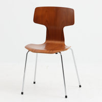 アルネ・ヤコブセンがデザインし、Fritz Hansenが製造した「T Chair」です。チーク材の成形合板による背座一体型のシェルは、背面上部を左右に広げた特徴的なシルエットと、身体に沿う緩やかな曲面が魅力。細身の金属脚との組み合わせが軽快で、ダイニングはもちろん、書斎や玄関のアクセントチェアにもおすすめです。美しい木目と時を重ねた風合い、合理的な構造に宿る北欧ビンテージらしい存在感を楽しめます。