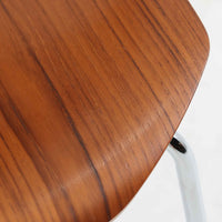 アルネ・ヤコブセンがデザインし、Fritz Hansenが製造した「T Chair」です。チーク材の成形合板による背座一体型のシェルは、背面上部を左右に広げた特徴的なシルエットと、身体に沿う緩やかな曲面が魅力。細身の金属脚との組み合わせが軽快で、ダイニングはもちろん、書斎や玄関のアクセントチェアにもおすすめです。美しい木目と時を重ねた風合い、合理的な構造に宿る北欧ビンテージらしい存在感を楽しめます。