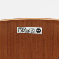 アルネ・ヤコブセンがデザインし、Fritz Hansenが製造した「T Chair」です。チーク材の成形合板による背座一体型のシェルは、背面上部を左右に広げた特徴的なシルエットと、身体に沿う緩やかな曲面が魅力。細身の金属脚との組み合わせが軽快で、ダイニングはもちろん、書斎や玄関のアクセントチェアにもおすすめです。美しい木目と時を重ねた風合い、合理的な構造に宿る北欧ビンテージらしい存在感を楽しめます。