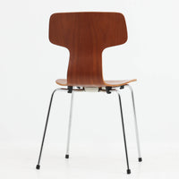 アルネ・ヤコブセンがデザインし、Fritz Hansenが製造した「T Chair」です。チーク材の成形合板による背座一体型のシェルは、背面上部を左右に広げた特徴的なシルエットと、身体に沿う緩やかな曲面が魅力。細身の金属脚との組み合わせが軽快で、ダイニングはもちろん、書斎や玄関のアクセントチェアにもおすすめです。美しい木目と時を重ねた風合い、合理的な構造に宿る北欧ビンテージらしい存在感を楽しめます。