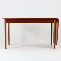 デンマークのHundevad & Co社によるバタフライ式のダイニングテーブルは、希少なチーク材を使用した上品な佇まいと、幅133cmから195cmへと片側の拡張板でサイズ調整が可能な機能性が魅力の一台です。普段はコンパクトに、必要に応じて天板を広げて使える設計は、日常から来客時まで幅広く活躍します。直線的なフレームと繊細な脚部が調和し、空間に北欧ビンテージらしい落ち着きと温かみを添えてくれます。