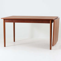 デンマークのHundevad & Co社によるバタフライ式のダイニングテーブルは、希少なチーク材を使用した上品な佇まいと、幅133cmから195cmへと片側の拡張板でサイズ調整が可能な機能性が魅力の一台です。普段はコンパクトに、必要に応じて天板を広げて使える設計は、日常から来客時まで幅広く活躍します。直線的なフレームと繊細な脚部が調和し、空間に北欧ビンテージらしい落ち着きと温かみを添えてくれます。