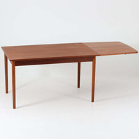 デンマークのHundevad & Co社によるバタフライ式のダイニングテーブルは、希少なチーク材を使用した上品な佇まいと、幅133cmから195cmへと片側の拡張板でサイズ調整が可能な機能性が魅力の一台です。普段はコンパクトに、必要に応じて天板を広げて使える設計は、日常から来客時まで幅広く活躍します。直線的なフレームと繊細な脚部が調和し、空間に北欧ビンテージらしい落ち着きと温かみを添えてくれます。