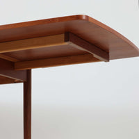 デンマークのHundevad & Co社によるバタフライ式のダイニングテーブルは、希少なチーク材を使用した上品な佇まいと、幅133cmから195cmへと片側の拡張板でサイズ調整が可能な機能性が魅力の一台です。普段はコンパクトに、必要に応じて天板を広げて使える設計は、日常から来客時まで幅広く活躍します。直線的なフレームと繊細な脚部が調和し、空間に北欧ビンテージらしい落ち着きと温かみを添えてくれます。