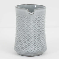 デンマークを代表するデザイナー、イェンス・H・クイストゴーによる「Cordial(コーディアル)」シリーズのヴィンテージ・ミルクジャグ(ピッチャー)です。1960年代にKronjydenから制作が始まったシリーズは、その後Nissen、Bing&Grondahlと引き継がれ長く愛されたシリーズとなりました。淡いグレーのストーンウェアにハートを連想させる繊細な型押し模様が施されており、デンマークではスウェーデンやフィンランドの陶器メーカーと並んで今でも非常に人気のある商品となります。