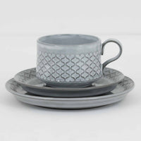 デンマークを代表するデザイナー、イェンス・H・クイストゴーによる「Cordial(コーディアル)」シリーズのヴィンテージ・トリオセット(ティーカップ、ソーサー、プレート)です。1960年代にKronjydenから制作が始まったシリーズは、その後Nissen、Bing&Grondahlと引き継がれ長く愛されたシリーズとなりました。淡いグレーのストーンウェアにハートを連想させる繊細な型押し模様が施されており、デンマークではスウェーデンやフィンランドの陶器メーカーと並んで今でも非常に人気のある商品となります。