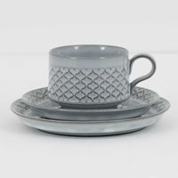 デンマークを代表するデザイナー、イェンス・H・クイストゴーによる「Cordial(コーディアル)」シリーズのヴィンテージ・トリオセット(ティーカップ、ソーサー、プレート)です。1960年代にKronjydenから制作が始まったシリーズは、その後Nissen、Bing&Grondahlと引き継がれ長く愛されたシリーズとなりました。淡いグレーのストーンウェアにハートを連想させる繊細な型押し模様が施されており、デンマークではスウェーデンやフィンランドの陶器メーカーと並んで今でも非常に人気のある商品となります。