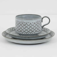 デンマークを代表するデザイナー、イェンス・H・クイストゴーによる「Cordial(コーディアル)」シリーズのヴィンテージ・トリオセット(ティーカップ、ソーサー、プレート)です。1960年代にKronjydenから制作が始まったシリーズは、その後Nissen、Bing&Grondahlと引き継がれ長く愛されたシリーズとなりました。淡いグレーのストーンウェアにハートを連想させる繊細な型押し模様が施されており、デンマークではスウェーデンやフィンランドの陶器メーカーと並んで今でも非常に人気のある商品となります。