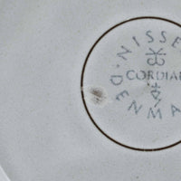デンマークを代表するデザイナー、イェンス・H・クイストゴーによる「Cordial(コーディアル)」シリーズのヴィンテージ・トリオセット(ティーカップ、ソーサー、プレート)です。1960年代にKronjydenから制作が始まったシリーズは、その後Nissen、Bing&Grondahlと引き継がれ長く愛されたシリーズとなりました。淡いグレーのストーンウェアにハートを連想させる繊細な型押し模様が施されており、デンマークではスウェーデンやフィンランドの陶器メーカーと並んで今でも非常に人気のある商品となります。