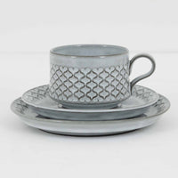 デンマークを代表するデザイナー、イェンス・H・クイストゴーによる「Cordial(コーディアル)」シリーズのヴィンテージ・トリオセット(ティーカップ、ソーサー、プレート)です。1960年代にKronjydenから制作が始まったシリーズは、その後Nissen、Bing&Grondahlと引き継がれ長く愛されたシリーズとなりました。淡いグレーのストーンウェアにハートを連想させる繊細な型押し模様が施されており、デンマークではスウェーデンやフィンランドの陶器メーカーと並んで今でも非常に人気のある商品となります。