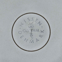 デンマークを代表するデザイナー、イェンス・H・クイストゴーによる「Cordial(コーディアル)」シリーズのヴィンテージ・トリオセット(ティーカップ、ソーサー、プレート)です。1960年代にKronjydenから制作が始まったシリーズは、その後Nissen、Bing&Grondahlと引き継がれ長く愛されたシリーズとなりました。淡いグレーのストーンウェアにハートを連想させる繊細な型押し模様が施されており、デンマークではスウェーデンやフィンランドの陶器メーカーと並んで今でも非常に人気のある商品となります。