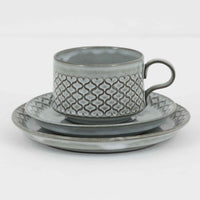 デンマークを代表するデザイナー、イェンス・H・クイストゴーによる「Cordial(コーディアル)」シリーズのヴィンテージ・トリオセット(ティーカップ、ソーサー、プレート)です。1960年代にKronjydenから制作が始まったシリーズは、その後Nissen、Bing&Grondahlと引き継がれ長く愛されたシリーズとなりました。淡いグレーのストーンウェアにハートを連想させる繊細な型押し模様が施されており、デンマークではスウェーデンやフィンランドの陶器メーカーと並んで今でも非常に人気のある商品となります。