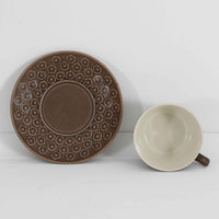 デンマークを代表するデザイナー、イェンス・H・クイストゴーによる「Azur(アズール)」シリーズのヴィンテージカッププ&ソーサーです。1960年代にKronjydenから制作が始まったシリーズは、その後Nissen、Bing&Grondahlと引き継がれ長く愛されたシリーズとなりました。落ち着いたブラウンとプラム色の繊細なフラワーレリーフが施されたストーンウェアは、自然の美しさを食卓にそっと運びます。特にAzurシリーズはヴィンテージ市場でも流通量が極めて少なく高価な逸品となります。