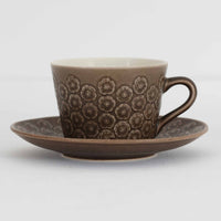 デンマークを代表するデザイナー、イェンス・H・クイストゴーによる「Azur(アズール)」シリーズのヴィンテージカッププ&ソーサーです。1960年代にKronjydenから制作が始まったシリーズは、その後Nissen、Bing&Grondahlと引き継がれ長く愛されたシリーズとなりました。落ち着いたブラウンとプラム色の繊細なフラワーレリーフが施されたストーンウェアは、自然の美しさを食卓にそっと運びます。特にAzurシリーズはヴィンテージ市場でも流通量が極めて少なく高価な逸品となります。