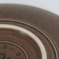 デンマークを代表するデザイナー、イェンス・H・クイストゴーによる「Azur(アズール)」シリーズのヴィンテージカッププ&ソーサーです。1960年代にKronjydenから制作が始まったシリーズは、その後Nissen、Bing&Grondahlと引き継がれ長く愛されたシリーズとなりました。落ち着いたブラウンとプラム色の繊細なフラワーレリーフが施されたストーンウェアは、自然の美しさを食卓にそっと運びます。特にAzurシリーズはヴィンテージ市場でも流通量が極めて少なく高価な逸品となります。