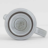 デンマークを代表するデザイナー、イェンス・H・クイストゴーによる「Cordial(コーディアル)」シリーズのヴィンテージ・ミルクジャグ(ピッチャー)です。1960年代にKronjydenから制作が始まったシリーズは、その後Nissen、Bing&Grondahlと引き継がれ長く愛されたシリーズとなりました。淡いグレーのストーンウェアにハートを連想させる繊細な型押し模様が施されており、デンマークではスウェーデンやフィンランドの陶器メーカーと並んで今でも非常に人気のある商品となります。