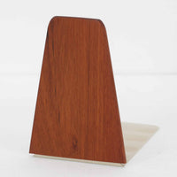 北欧デザインの温もりを感じさせる、デンマーク製ヴィンテージのブックエンドです。1960〜80年代頃に製造されたとみられ、素材には希少なチーク材を使用。深みのある色合いと美しい木目は、経年によってさらに味わいを増し、空間に落ち着きと上質さをもたらします。シンプルでありながら洗練されたフォルムは、北欧モダンらしいミニマルな美しさを体現しており、実用性とインテリア性を兼ね備え、書棚やデスクまわりを上品に演出します。