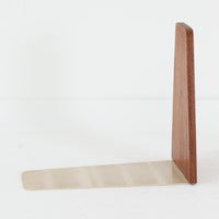 北欧デザインの温もりを感じさせる、デンマーク製ヴィンテージのブックエンドです。1960〜80年代頃に製造されたとみられ、素材には希少なチーク材を使用。深みのある色合いと美しい木目は、経年によってさらに味わいを増し、空間に落ち着きと上質さをもたらします。シンプルでありながら洗練されたフォルムは、北欧モダンらしいミニマルな美しさを体現しており、実用性とインテリア性を兼ね備え、書棚やデスクまわりを上品に演出します。