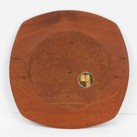 1960年代、デンマーク・モダンの黄金期にポール・クヌーセンが手がけたチーク無垢材のプレートです。「実用工芸」を意味するブランド名の通り、木の質感を活かした滑らかな曲線と、洗練されたミニマルな造形美が魅力。半世紀を経て深く色づいたチーク材は「木の宝石」と称されるほど美しく、食卓に温かな品格を添えます。食器としてはもちろん、インテリアトレイとしても重宝する、一期一会のヴィンテージ名作です。