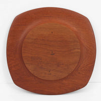 1960年代、デンマーク・モダンの黄金期にポール・クヌーセンが手がけたチーク無垢材のプレートです。「実用工芸」を意味するブランド名の通り、木の質感を活かした滑らかな曲線と、洗練されたミニマルな造形美が魅力。半世紀を経て深く色づいたチーク材は「木の宝石」と称されるほど美しく、食卓に温かな品格を添えます。食器としてはもちろん、インテリアトレイとしても重宝する、一期一会のヴィンテージ名作です。