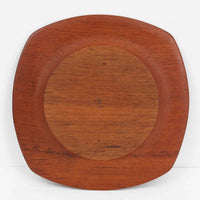 1960年代、デンマーク・モダンの黄金期にポール・クヌーセンが手がけたチーク無垢材のプレートです。「実用工芸」を意味するブランド名の通り、木の質感を活かした滑らかな曲線と、洗練されたミニマルな造形美が魅力。半世紀を経て深く色づいたチーク材は「木の宝石」と称されるほど美しく、食卓に温かな品格を添えます。食器としてはもちろん、インテリアトレイとしても重宝する、一期一会のヴィンテージ名作です。