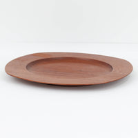 1960年代、デンマーク・モダンの黄金期にポール・クヌーセンが手がけたチーク無垢材のプレートです。「実用工芸」を意味するブランド名の通り、木の質感を活かした滑らかな曲線と、洗練されたミニマルな造形美が魅力。半世紀を経て深く色づいたチーク材は「木の宝石」と称されるほど美しく、食卓に温かな品格を添えます。食器としてはもちろん、インテリアトレイとしても重宝する、一期一会のヴィンテージ名作です。