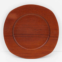 1960年代、デンマーク・モダンの黄金期にポール・クヌーセンが手がけたチーク無垢材のプレートです。「実用工芸」を意味するブランド名の通り、木の質感を活かした滑らかな曲線と、洗練されたミニマルな造形美が魅力。半世紀を経て深く色づいたチーク材は「木の宝石」と称されるほど美しく、食卓に温かな品格を添えます。食器としてはもちろん、インテリアトレイとしても重宝する、一期一会のヴィンテージ名作です。