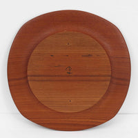 1960年代、デンマーク・モダンの黄金期にポール・クヌーセンが手がけたチーク無垢材のプレートです。「実用工芸」を意味するブランド名の通り、木の質感を活かした滑らかな曲線と、洗練されたミニマルな造形美が魅力。半世紀を経て深く色づいたチーク材は「木の宝石」と称されるほど美しく、食卓に温かな品格を添えます。食器としてはもちろん、インテリアトレイとしても重宝する、一期一会のヴィンテージ名作です。