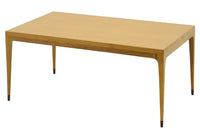 スレンダーな脚が特徴のセンターテーブルです。天板は長方形でシンプルに、コーナーにジョイントされた四角い脚は先端に向かって徐々に丸くなるよう削りだしており、スタイリッシュで美しいデザインに仕上げています。ハンドメイドで一つ一つ丁寧に削り出した脚は天板との一体感があり、まるで完成品かのような仕上がりです。また、汚れやすいとされる足先には汚れが目立ちにくいように、そしてまるで美しい脚に見えるようにと、ひと手間かけてローズウッド材(現在はチーク材のローズウッドカラー塗装への仕様変更となっています)をジョイントしています。