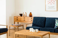 スレンダーな脚が特徴のワイドチェストです。チェスト本体はシンプルに、コーナーにジョイントされた四角い脚は先端に向かって徐々に丸くなるよう削りだしており、スタイリッシュで美しいデザインに仕上げています。ハンドメイドで一つ一つ丁寧に削り出した脚はチェスト本体との一体感があり、まるで完成品かのような仕上がりです。また、汚れやすいとされる足先には汚れが目立ちにくいように、そしてまるで美しい脚に見えるようにと、ひと手間かけてローズウッド材(現在はチーク材のローズウッドカラー塗装への仕様変更となっています)をジョイントしています。