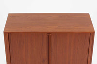 こちらは、カイ・クリスチャンセンによる小ぶりなローボードです。シンプルなデザインが特徴的で、ミニマリストなインテリアに調和します。本体には上質なチーク材が使用されており、美しい木目が目を引きます。北欧家具らしい蛇腹式扉が採用されており、開けた際にスペースを取らず、スマートな印象を与えます。内部にはレコード収納スペースが設けられており、レコードだけでなく書籍、DVDやBlu-rayディスク、ゲームソフト、デジタルメディアプレーヤーやゲームコンソールなど、さまざまなアイテムを収納できます。さらに、ハードウェアやアクセサリー、収納ボックスなどの整理に最適です。