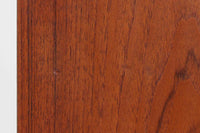 こちらは、カイ・クリスチャンセンによる小ぶりなローボードです。シンプルなデザインが特徴的で、ミニマリストなインテリアに調和します。本体には上質なチーク材が使用されており、美しい木目が目を引きます。北欧家具らしい蛇腹式扉が採用されており、開けた際にスペースを取らず、スマートな印象を与えます。内部にはレコード収納スペースが設けられており、レコードだけでなく書籍、DVDやBlu-rayディスク、ゲームソフト、デジタルメディアプレーヤーやゲームコンソールなど、さまざまなアイテムを収納できます。さらに、ハードウェアやアクセサリー、収納ボックスなどの整理に最適です。