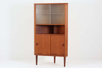 北欧より買い付けたビンテージ品のコーナーキャビネットです。良質なチーク材で作られたこのキャビネットは、耐久性と美しさを兼ね備えています。ガラス扉は内部の展示品を美しく飾り、収納スペースは引き戸で、使いやすさと機能性を高めています。このキャビネットは、北欧の伝統的な職人技を感じさせ、お部屋に上品で温かみのある雰囲気を醸し出します。