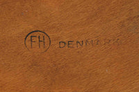 1954年、デンマークのデザイナー、Arne Jacobsen(アルネ・ヤコブセン)によって発表された3本脚のスツール、「DOT(ドット)」。このスツールは、ヤコブセンが手がけた「ルードブレ市庁舎」のロビーで待合席として使用されていました。1970年には4本脚のバージョンも登場しましたが、3本脚のモデルは同年に廃盤となり、現在はビンテージ品のみで入手可能です。オフィスや自宅での日常的な使用はもちろん、予備の椅子としても便利なこのスツールは、シンプルなデザインが魅力です。座面の中央がわずかにくぼんでおり、座った際にフィット感を生み出します。シンプルながらもヤコブセンのこだわりが感じられ、また、単なるスツールとしてだけでなく、ソファの横に置いて本や小物を置くサイドテーブルとしても活用できます。座面裏には薄っすらとFritz Hansen社の刻印がございます。