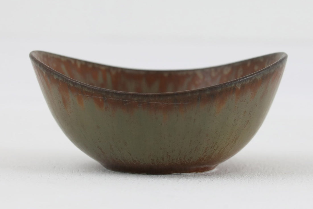 フィンランド人で彫刻家の父と、デンマーク人で陶芸家の母の元に育つGunnarNylundはデンマークで建築を学んだ後、Bing&Grondahl窯、スウェーデンRorstrand窯に就業し、多くの作品を生み出しています。彼の作品は独特な流線型と釉薬が特徴で世界中で重宝されています。AROボウルは彼の最も代表的な作品で、その緩やかな美しいカーブが特徴です。また、さまざまな表情をみせる釉薬がコレクターにも人気がある理由です。