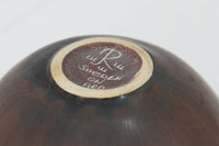 フィンランド人で彫刻家の父と、デンマーク人で陶芸家の母の元に育つGunnarNylundはデンマークで建築を学んだ後、Bing&Grondahl窯、スウェーデンRorstrand窯に就業し、多くの作品を生み出しています。彼の作品は独特な流線型と釉薬が特徴で世界中で重宝されています。AROボウルは彼の最も代表的な作品で、その緩やかな美しいカーブが特徴です。また、さまざまな表情をみせる釉薬がコレクターにも人気がある理由です。