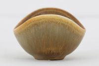 フィンランド人で彫刻家の父と、デンマーク人で陶芸家の母の元に育つGunnarNylundはデンマークで建築を学んだ後、Bing&Grondahl窯、スウェーデンRorstrand窯に就業し、多くの作品を生み出しています。彼の作品は独特な流線型と釉薬が特徴で世界中で重宝されています。AROボウルは彼の最も代表的な作品で、その緩やかな美しいカーブが特徴です。また、さまざまな表情をみせる釉薬がコレクターにも人気がある理由です。