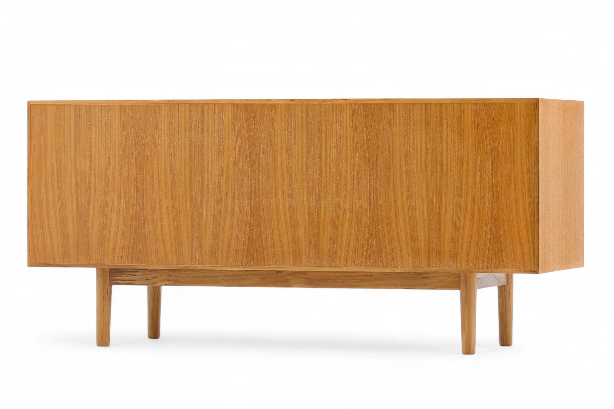 ナチュラルテイストのローボード120です。上質なチーク材を使用し、シンプルですがデザイン性の高いアイテムです。あえて余計な塗装をあまりせず、木本来の味わいを楽しめる作りになっています。取手には現在入手困難なローズウッド（現在はチーク材のローズウッドカラー塗装への仕様変更となっています）を使用し、コントラストの美しさが感じられる仕上がりになっています。通常安価な白木などが用いられる裏面や引き出しの内部にも全て上質なチーク材を使用しており高級感があります。 旧タイプから木材のグレードや、コードホールのステルス化などが変更になっています。