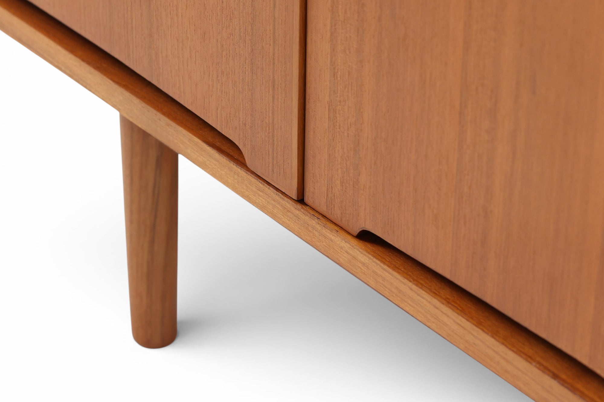 北欧モダンスタイルのワイドキャビネットです。取っ手を葉っぱの形に削りだしているのが特徴的なデザインです。上部には引出収納を４つ、下部には扉収納を２つ備えています。下部収納部の棚板は高さ調整可能、取り外しも可能です。使い勝手も良好で、収納時見た目にも大変上品で美しい雰囲気があります。素材は脚も含め全てチーク材を使用しており、美しい暖かな風合いの木目が心地よさを演出します。少し小さめなのがお部屋を圧迫することもなくおしゃれに演出することが可能です。