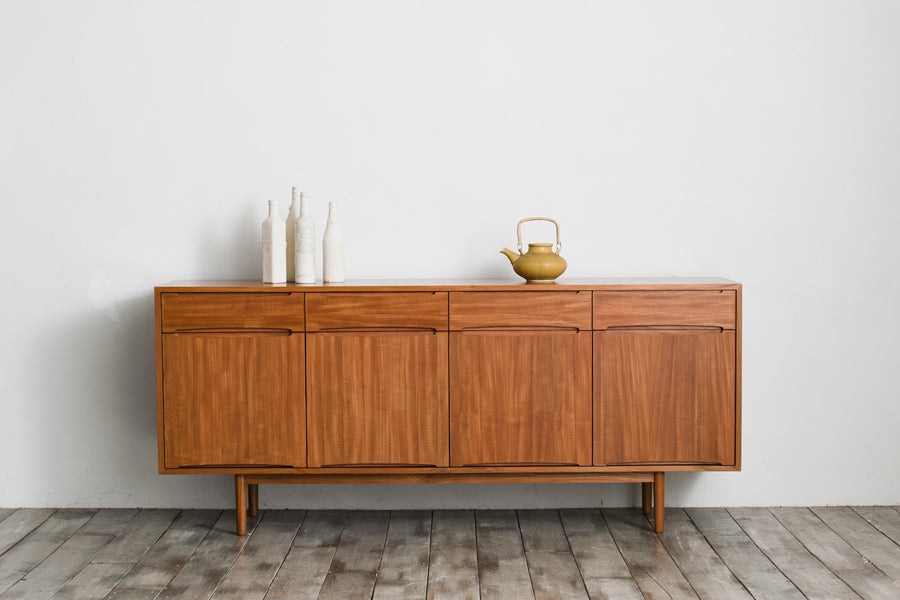 北欧モダンスタイルのワイドキャビネットです。取っ手を葉っぱの形に削りだしているのが特徴的なデザインです。上部には引出収納を４つ、下部には扉収納を２つ備えています。下部収納部の棚板は高さ調整可能、取り外しも可能です。使い勝手も良好で、収納時見た目にも大変上品で美しい雰囲気があります。素材は脚も含め全てチーク材を使用しており、美しい暖かな風合いの木目が心地よさを演出します。少し小さめなのがお部屋を圧迫することもなくおしゃれに演出することが可能です。