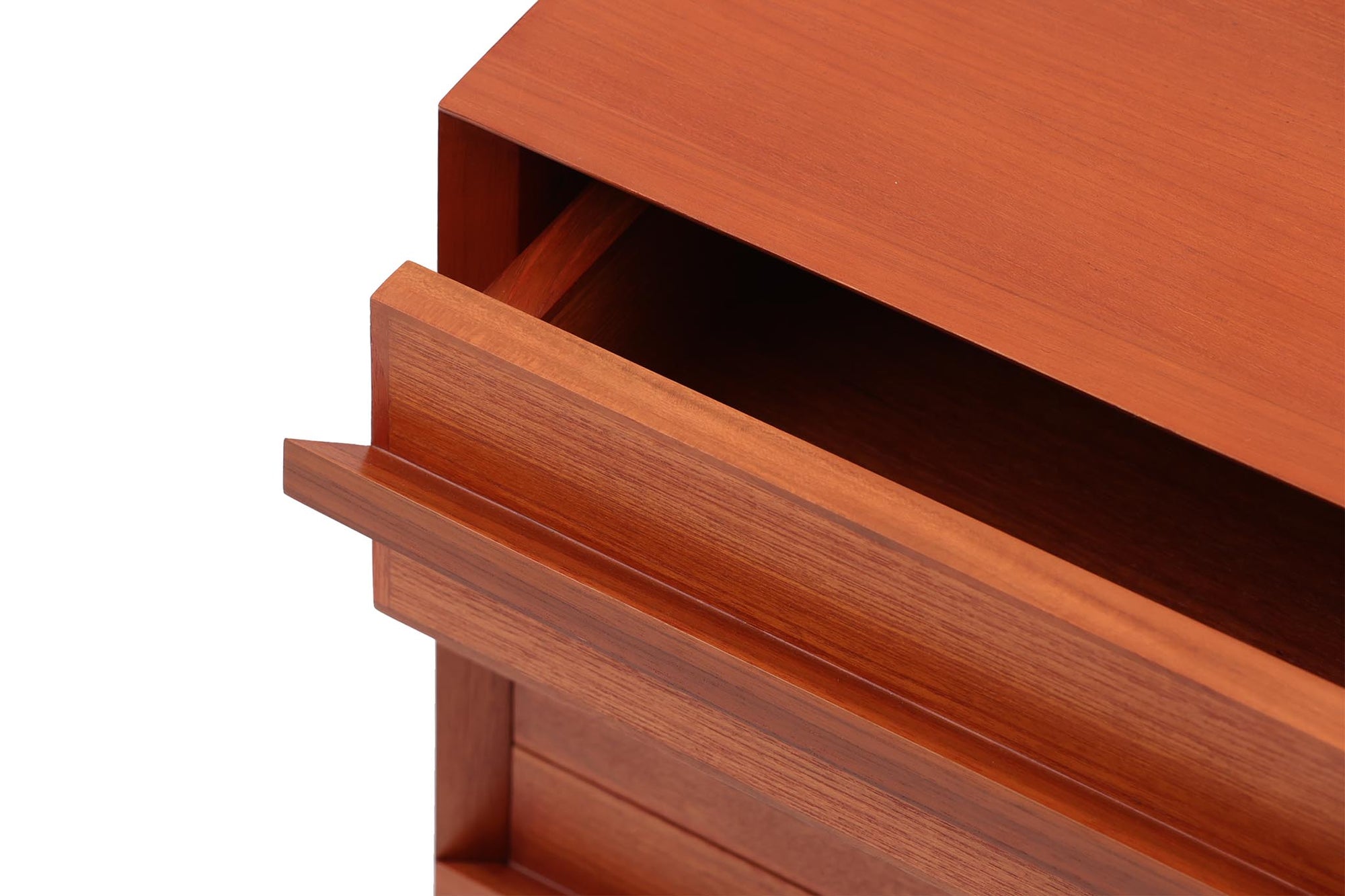 チーク材のテレビボードです。刃物のようなデザインの取手が特徴的で、収納時には非常にモダンで美しい印象を与えます。またこちらの長い取っ手は開け閉め時、ストレス無く、使い勝手がよいのも特徴です。チェスト本体の外枠が正面に対してフラットではなく斜めになっているなど高級感のあるデザインに仕上げています。