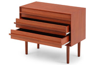 チーク材の３段チェストです。刃物のようなデザインの取っ手がチェスト本体と一体化することで収納時、非常にモダンで美しい印象を与えます。またこちらの長い取っ手は開け閉め時、ストレス無く、使い勝手がよいのも特徴です。チェスト本体の外枠が正面に対してフラットではなく斜めになっているなど高級感のあるデザインに仕上げています。