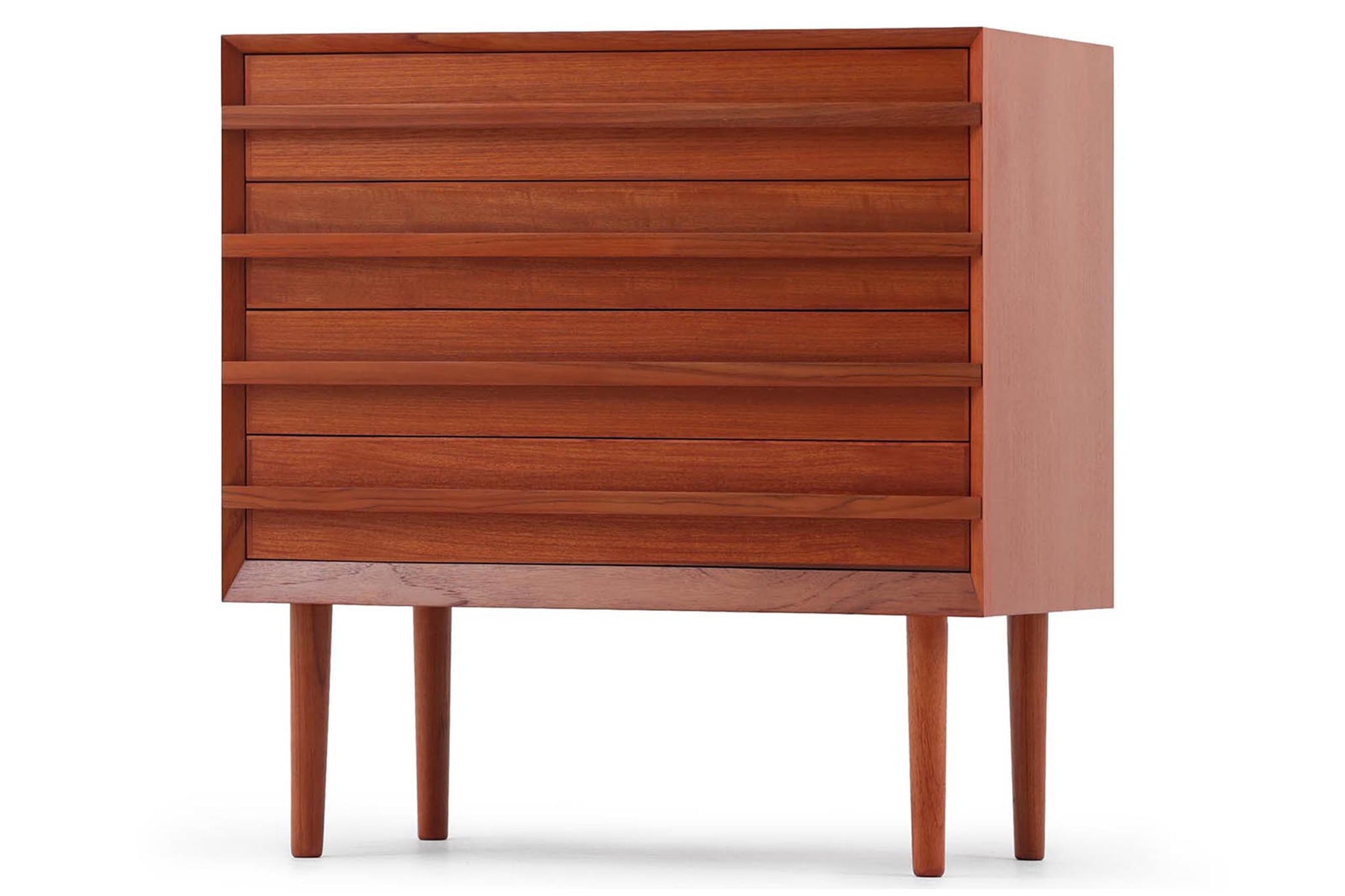 チーク材の４段チェストです。刃物のようなデザインの取っ手がチェスト本体と一体化することで収納時、非常にモダンで美しい印象を与えます。またこちらの長い取っ手は開け閉め時、ストレス無く、使い勝手がよいのも特徴です。チェスト本体の外枠が正面に対してフラットではなく斜めになっているなど高級感のあるデザインに仕上げています。