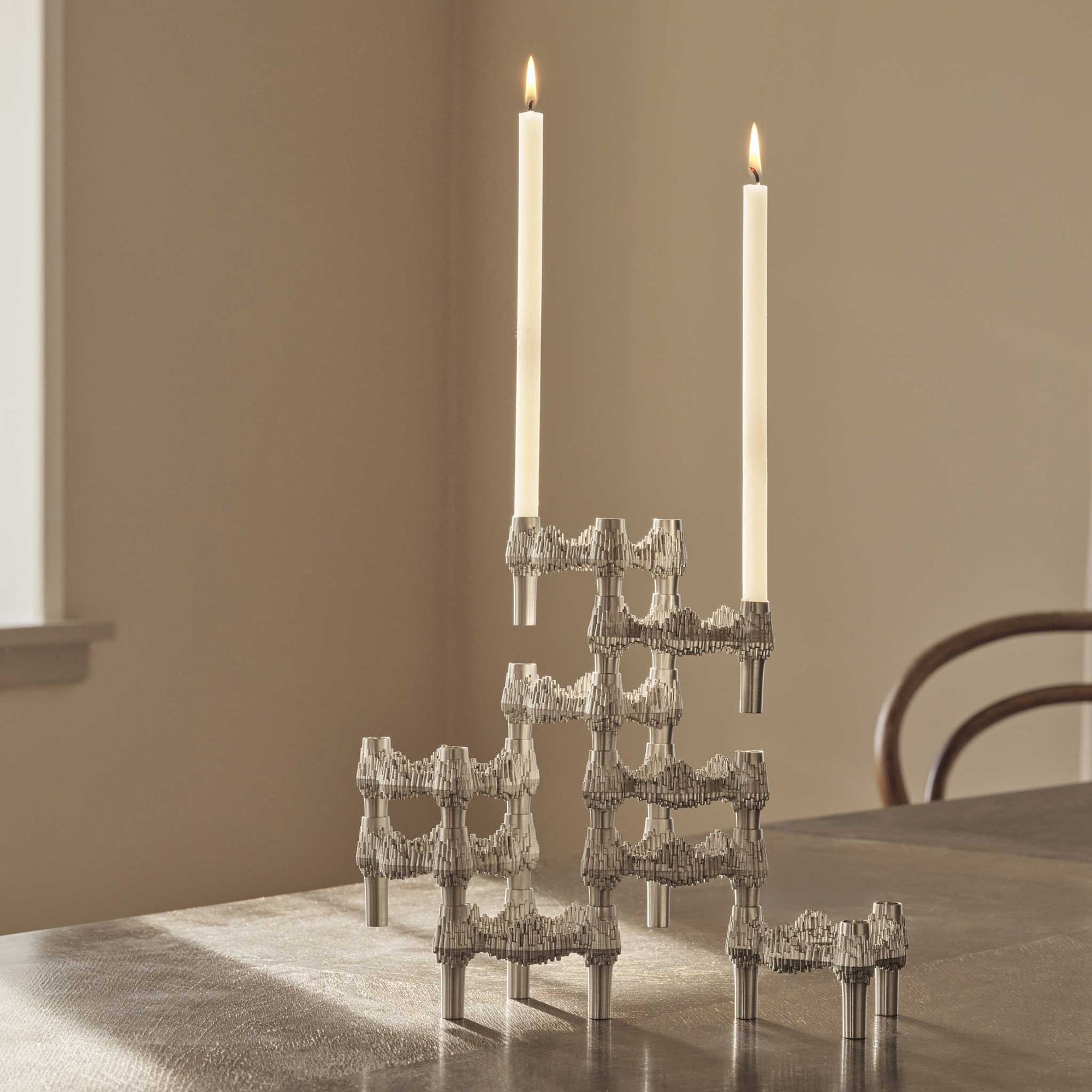 Stoff（ストッフ）は、デンマーク発のデザインブランドで、1960年代の名作「Stoff Nagel（ストッフ・ナゲル）」キャンドルホルダーの復刻から始まりました。建築家Werner Stoff（ヴェルナー・ストッフ）と、ドイツのHans Nagel（ハンス・ナゲル）によって生み出されたこのモジュール式キャンドルホルダーは、彫刻のような幾何学美と、自由な組み合わせによる創造性を兼ね備えたインテリアアートです。現在のStoffは、オリジナルの精神を受け継ぎながら、現代のライフスタイルに合う素材や仕上げを追加し、キャンドルホルダーだけでなくフラワーベースやボウル、ウォールハンガーなど洗練されたアイテムを展開。ミッドセンチュリーや北欧インテリアに調和し、空間に立体感と静謐な存在感を与えます。構築と装飾の境界を超えたStoffの作品は、機能性と造形美が共存する稀有なプロダクトです。