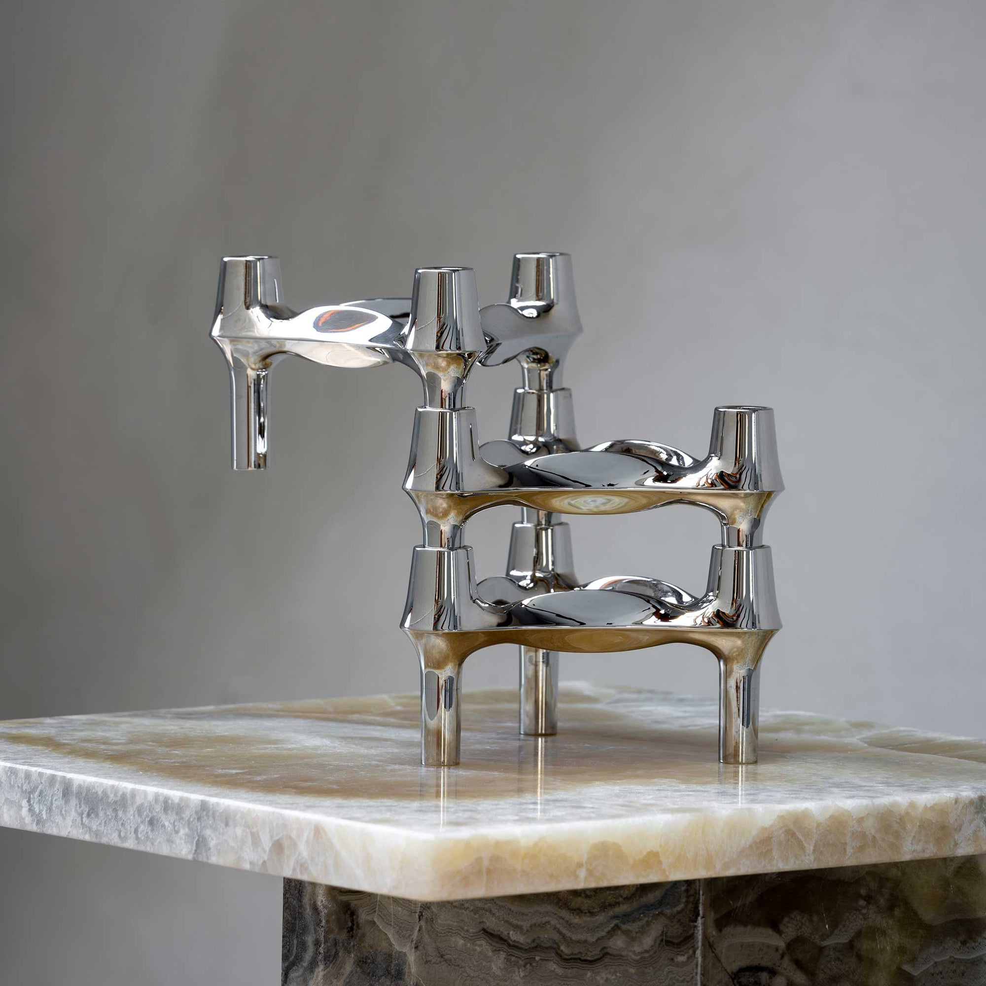 Stoff（ストッフ）は、デンマーク発のデザインブランドで、1960年代の名作「Stoff Nagel（ストッフ・ナゲル）」キャンドルホルダーの復刻から始まりました。建築家Werner Stoff（ヴェルナー・ストッフ）と、ドイツのHans Nagel（ハンス・ナゲル）によって生み出されたこのモジュール式キャンドルホルダーは、彫刻のような幾何学美と、自由な組み合わせによる創造性を兼ね備えたインテリアアートです。現在のStoffは、オリジナルの精神を受け継ぎながら、現代のライフスタイルに合う素材や仕上げを追加し、キャンドルホルダーだけでなくフラワーベースやボウル、ウォールハンガーなど洗練されたアイテムを展開。ミッドセンチュリーや北欧インテリアに調和し、空間に立体感と静謐な存在感を与えます。構築と装飾の境界を超えたStoffの作品は、機能性と造形美が共存する稀有なプロダクトです。