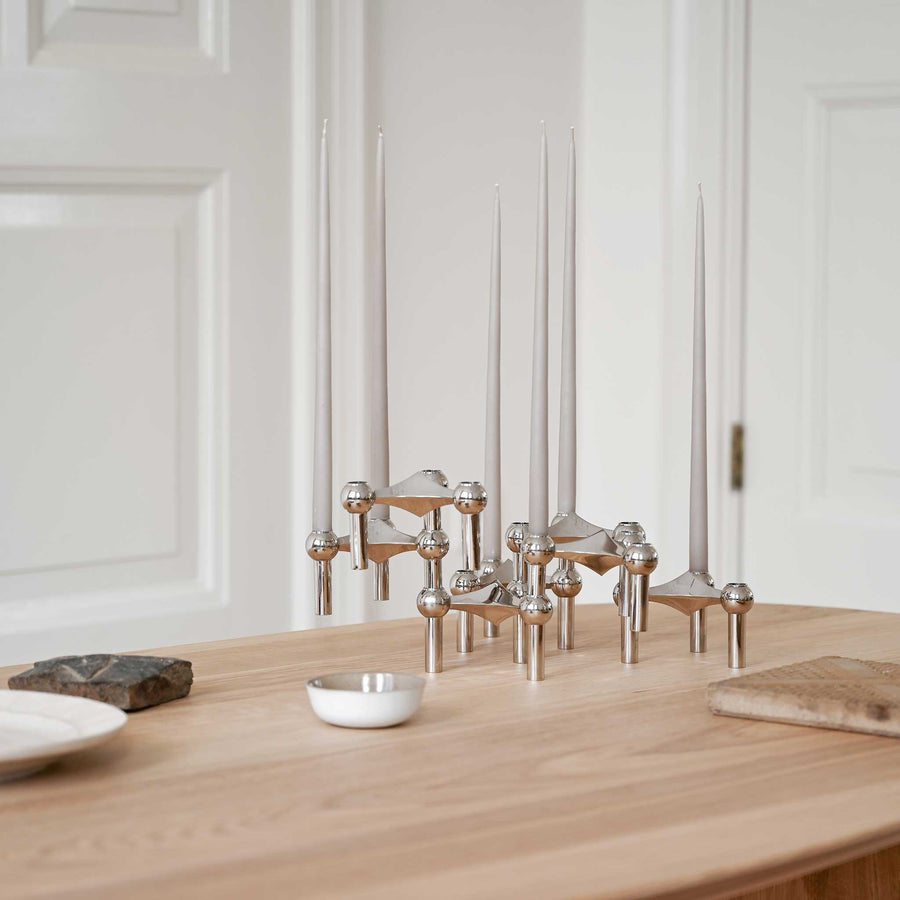 Stoff（ストッフ）は、デンマーク発のデザインブランドで、1960年代の名作「Stoff Nagel（ストッフ・ナゲル）」キャンドルホルダーの復刻から始まりました。建築家Werner Stoff（ヴェルナー・ストッフ）と、ドイツのHans Nagel（ハンス・ナゲル）によって生み出されたこのモジュール式キャンドルホルダーは、彫刻のような幾何学美と、自由な組み合わせによる創造性を兼ね備えたインテリアアートです。現在のStoffは、オリジナルの精神を受け継ぎながら、現代のライフスタイルに合う素材や仕上げを追加し、キャンドルホルダーだけでなくフラワーベースやボウル、ウォールハンガーなど洗練されたアイテムを展開。ミッドセンチュリーや北欧インテリアに調和し、空間に立体感と静謐な存在感を与えます。構築と装飾の境界を超えたStoffの作品は、機能性と造形美が共存する稀有なプロダクトです。