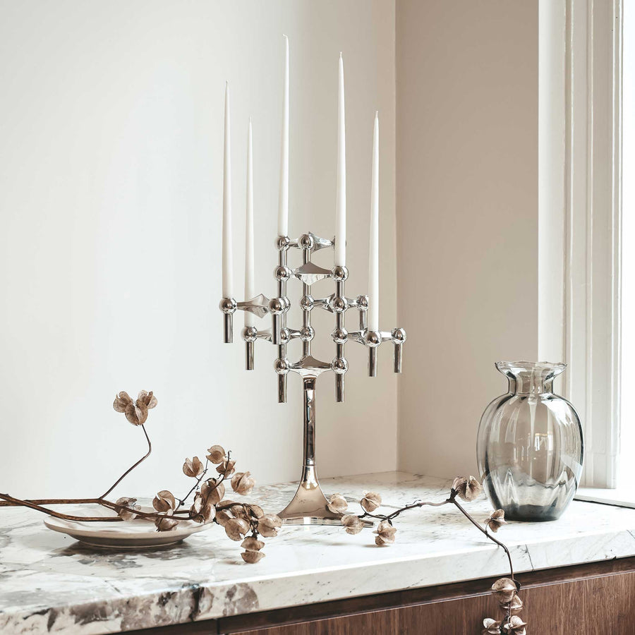 Stoff（ストッフ）は、デンマーク発のデザインブランドで、1960年代の名作「Stoff Nagel（ストッフ・ナゲル）」キャンドルホルダーの復刻から始まりました。建築家Werner Stoff（ヴェルナー・ストッフ）と、ドイツのHans Nagel（ハンス・ナゲル）によって生み出されたこのモジュール式キャンドルホルダーは、彫刻のような幾何学美と、自由な組み合わせによる創造性を兼ね備えたインテリアアートです。現在のStoffは、オリジナルの精神を受け継ぎながら、現代のライフスタイルに合う素材や仕上げを追加し、キャンドルホルダーだけでなくフラワーベースやボウル、ウォールハンガーなど洗練されたアイテムを展開。ミッドセンチュリーや北欧インテリアに調和し、空間に立体感と静謐な存在感を与えます。構築と装飾の境界を超えたStoffの作品は、機能性と造形美が共存する稀有なプロダクトです。