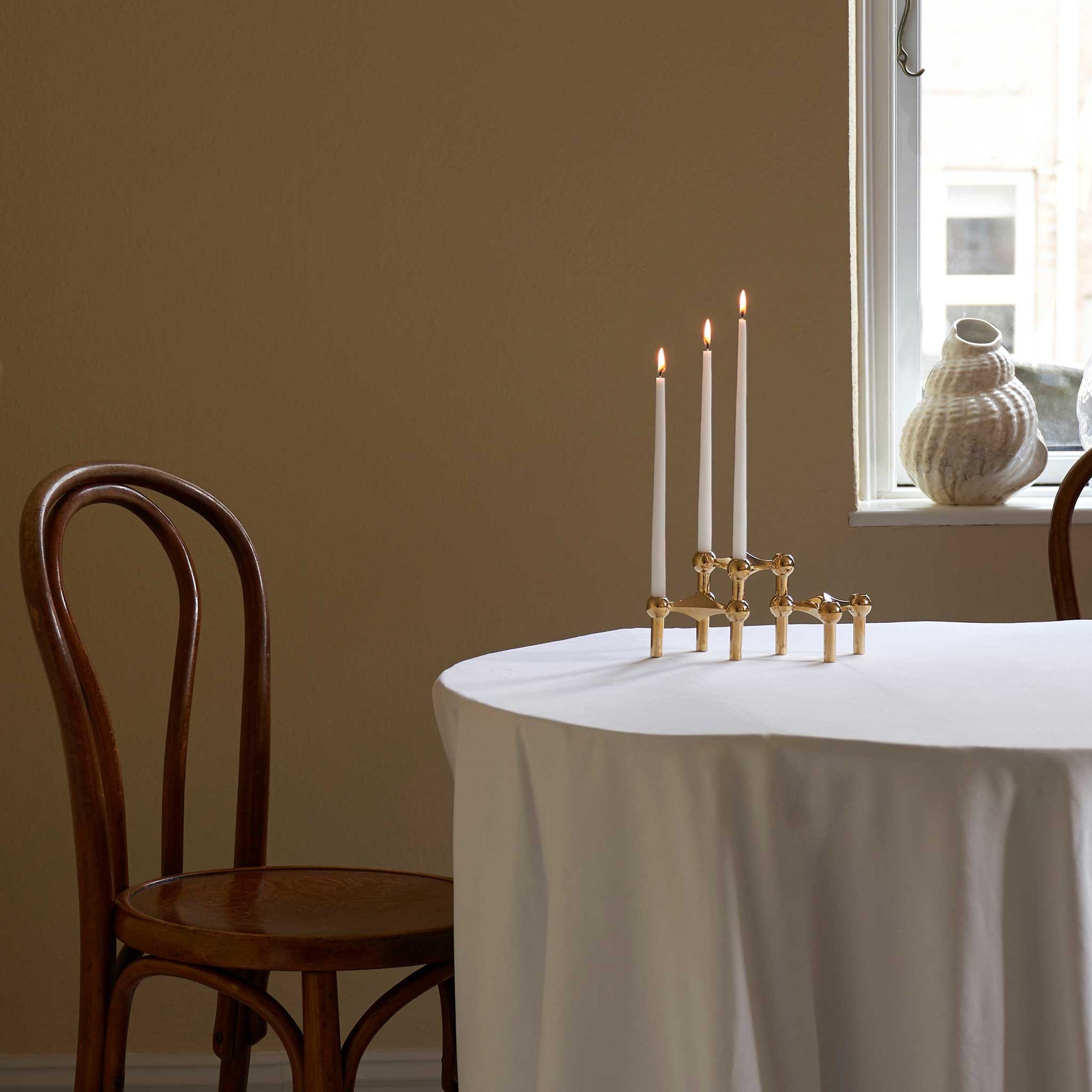 Stoff（ストッフ）は、デンマーク発のデザインブランドで、1960年代の名作「Stoff Nagel（ストッフ・ナゲル）」キャンドルホルダーの復刻から始まりました。建築家Werner Stoff（ヴェルナー・ストッフ）と、ドイツのHans Nagel（ハンス・ナゲル）によって生み出されたこのモジュール式キャンドルホルダーは、彫刻のような幾何学美と、自由な組み合わせによる創造性を兼ね備えたインテリアアートです。現在のStoffは、オリジナルの精神を受け継ぎながら、現代のライフスタイルに合う素材や仕上げを追加し、キャンドルホルダーだけでなくフラワーベースやボウル、ウォールハンガーなど洗練されたアイテムを展開。ミッドセンチュリーや北欧インテリアに調和し、空間に立体感と静謐な存在感を与えます。構築と装飾の境界を超えたStoffの作品は、機能性と造形美が共存する稀有なプロダクトです。